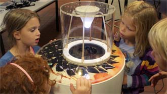 Kinder betrachten ein physikalisches Experiment